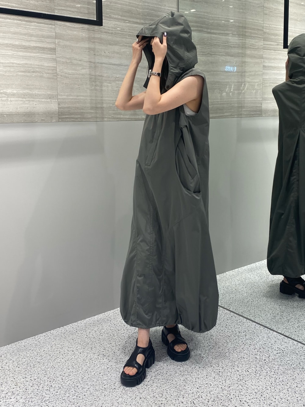 グレー系のワンピース、ブラック系のサンダルを着用したレディースの秋コーディネートの2枚目の写真