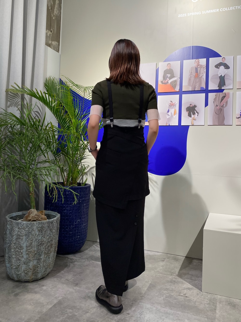 ブラック系のスカート、グリーン系のニット/セーター、シルバー系のショルダーバッグを着用したレディースの冬コーディネートの3枚目の写真