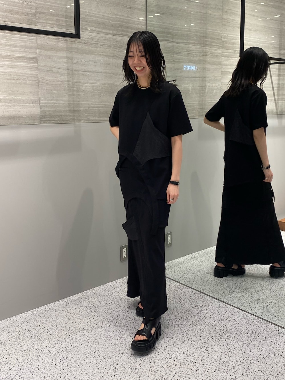 ブラック系のスカート、ブラック系のサンダル、ブラック系のTシャツ/カットソーを着用したレディースの春コーディネートの2枚目の写真