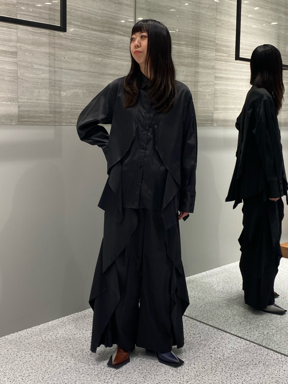 ブラック系のシャツ/ブラウス、ブラック系のその他パンツ、その他のブーツを着用したレディースの秋コーディネートの2枚目の写真