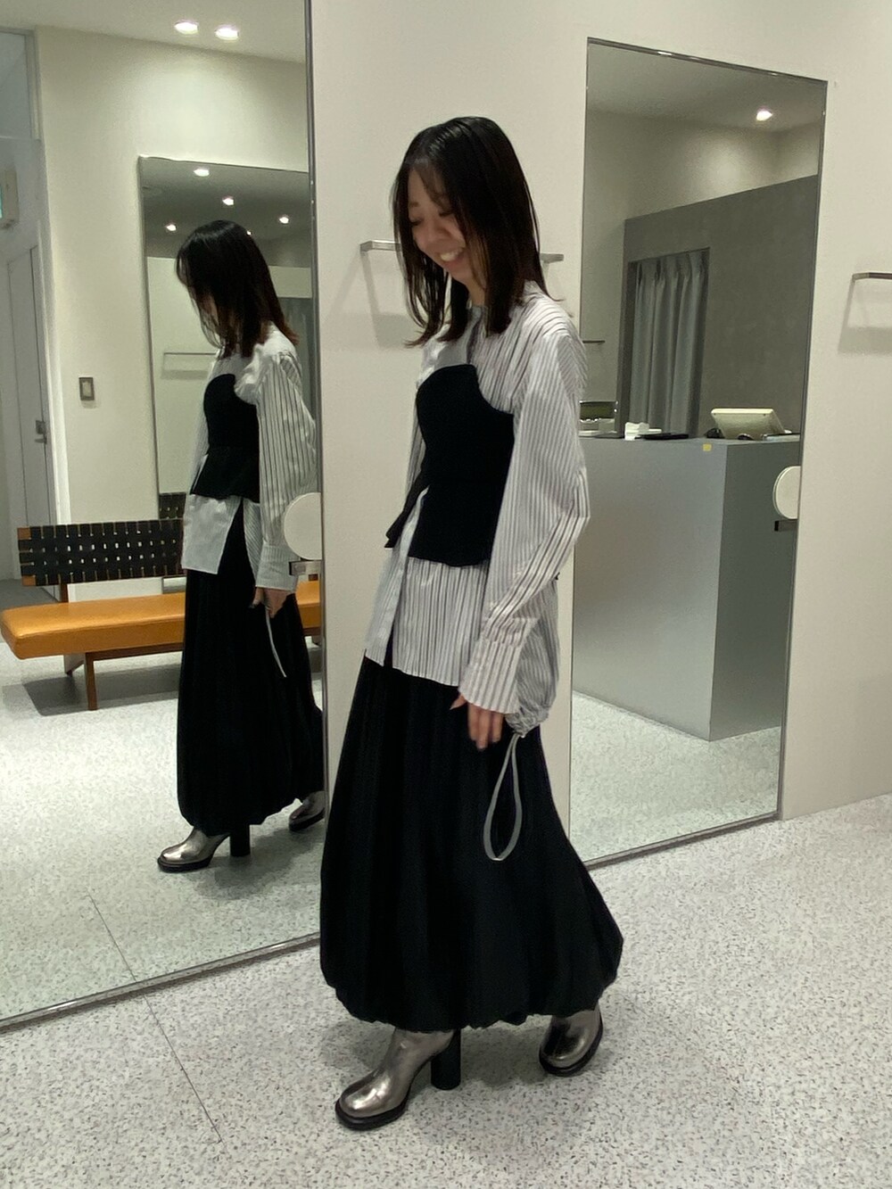 ブラック系のシャツ/ブラウス、ブラック系のスカート、シルバー系のブーツを着用したレディースの冬コーディネートの3枚目の写真