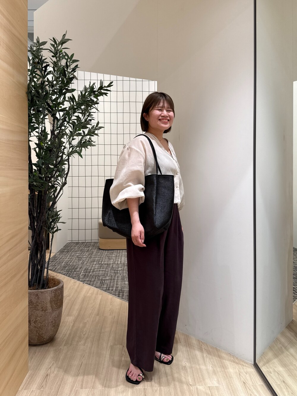 ベージュ系のシャツ/ブラウス、グレー系のその他パンツ、ブラック系のトートバッグを着用したレディースの夏コーディネートの3枚目の写真