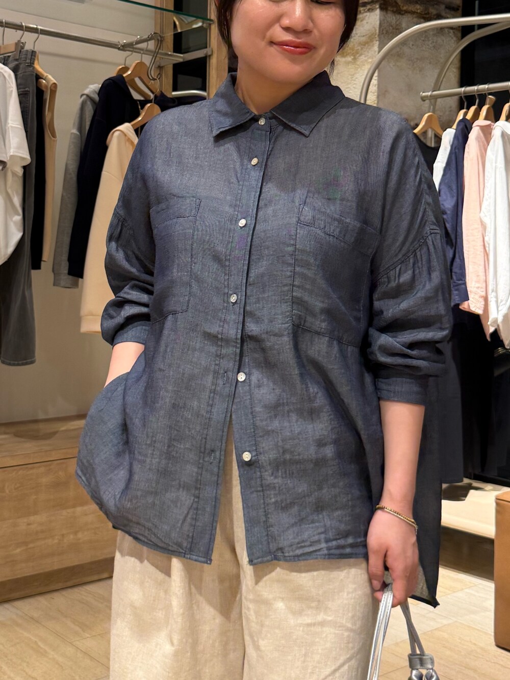 ブルー系のシャツ/ブラウス、ベージュ系のその他パンツ、シルバー系のトートバッグを着用したレディースの春コーディネートの4枚目の写真