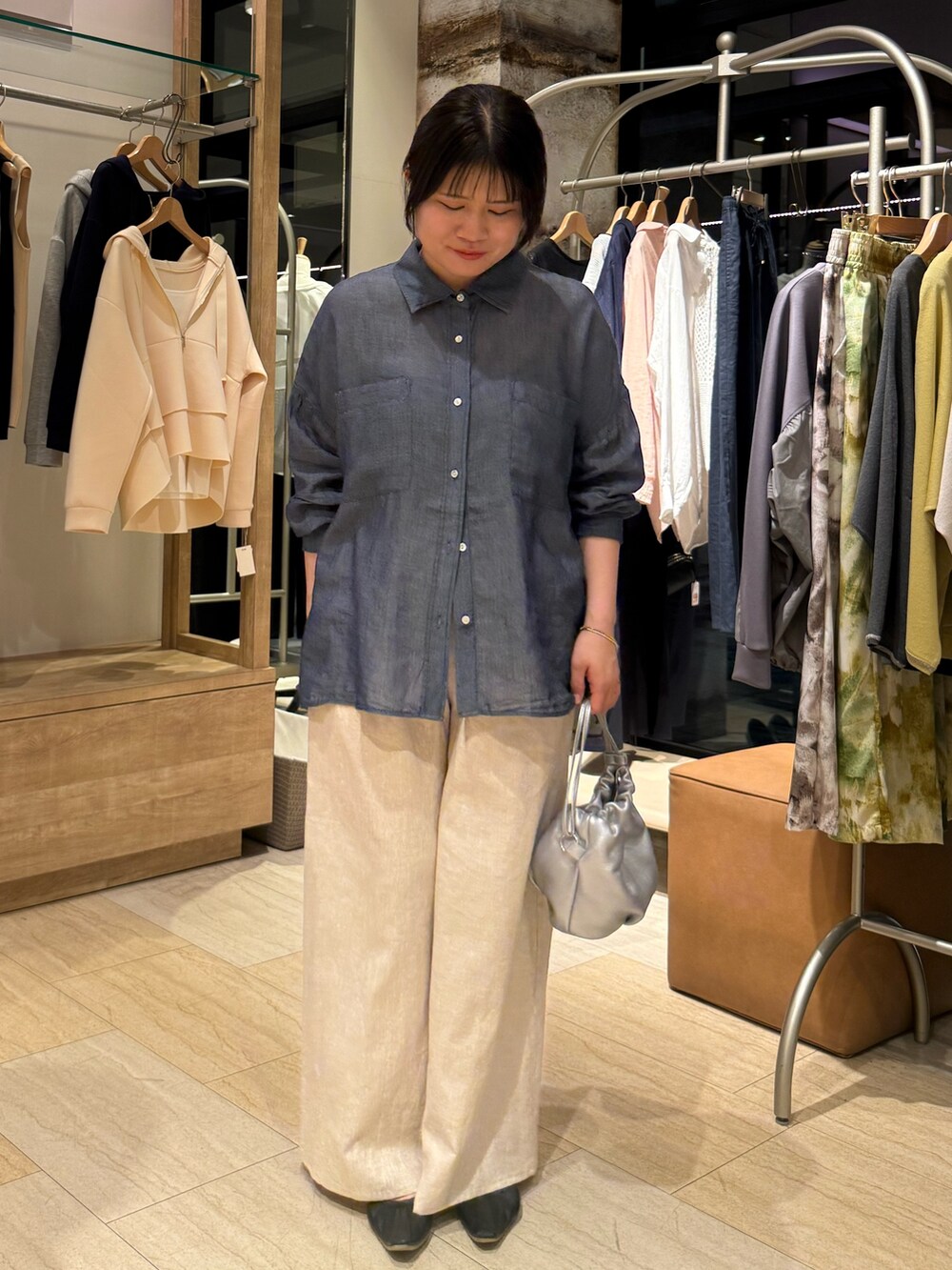 ブルー系のシャツ/ブラウス、ベージュ系のその他パンツ、シルバー系のトートバッグを着用したレディースの春コーディネートの2枚目の写真