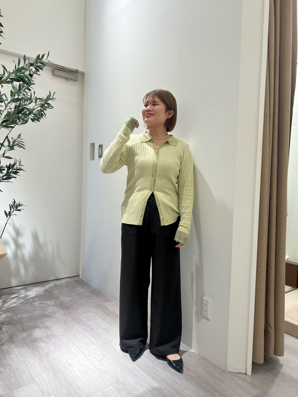 グリーン系のニット/セーター、グレー系のその他パンツを着用したレディースの冬コーディネートの2枚目の写真