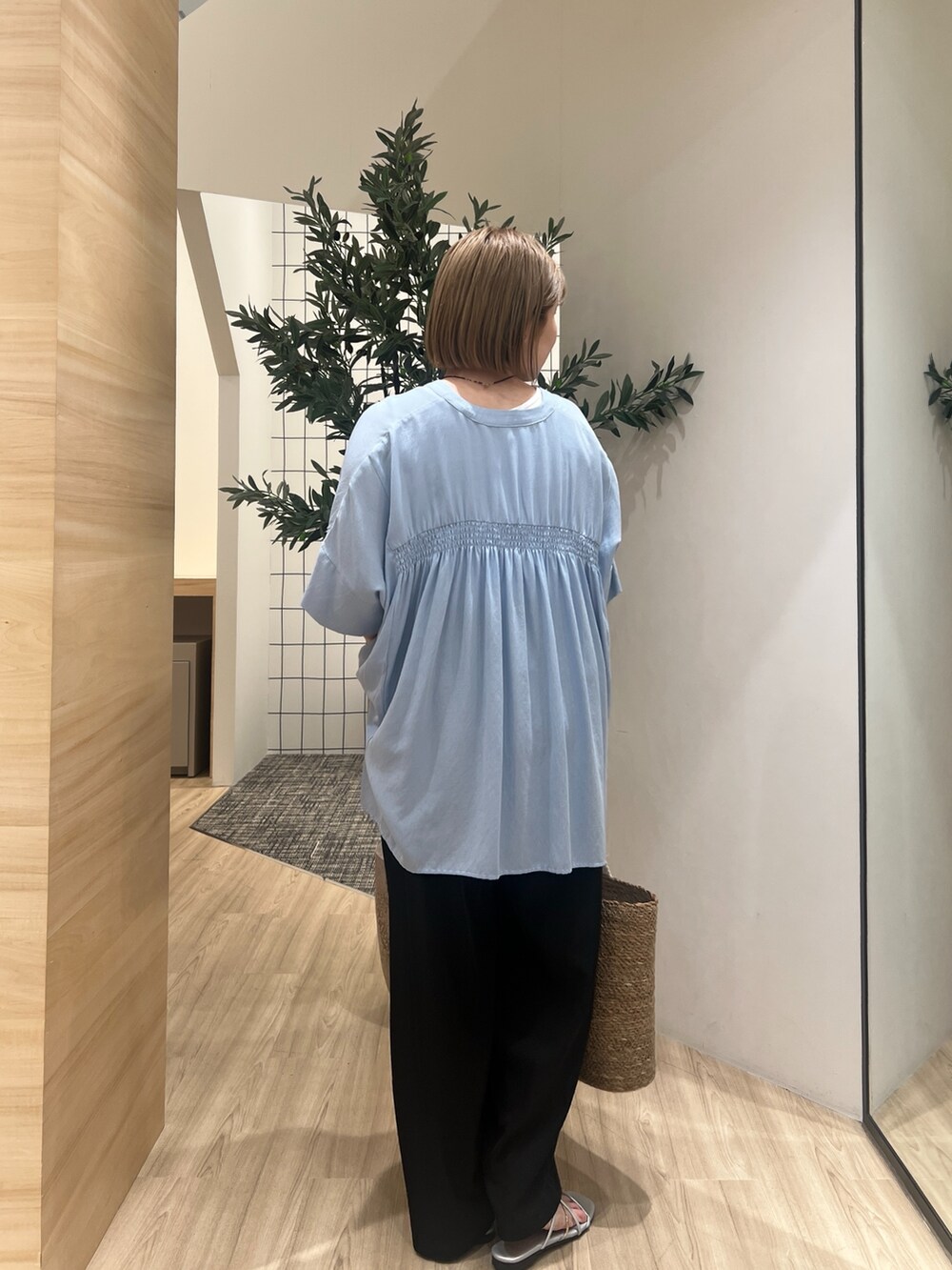 ブルー系のシャツ/ブラウス、ブラック系のその他パンツ、ホワイト系のトートバッグを着用したレディースの春コーディネートの3枚目の写真