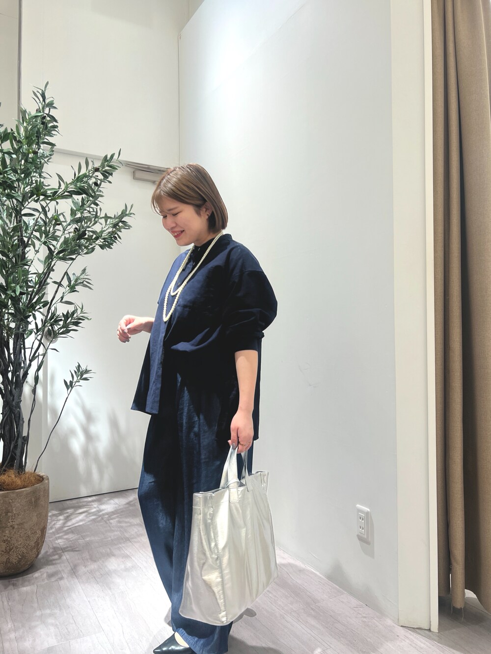 ブルー系のシャツ/ブラウス、ブルー系のその他パンツ、シルバー系のトートバッグを着用したレディースの春コーディネートの2枚目の写真