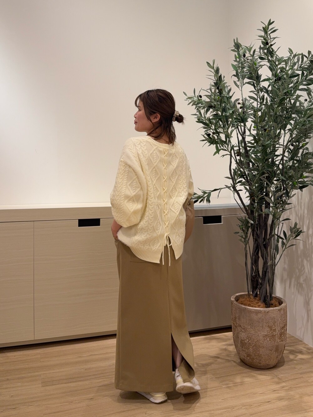 ホワイト系のニット/セーター、グリーン系のスカートを着用したレディースの秋コーディネートの2枚目の写真