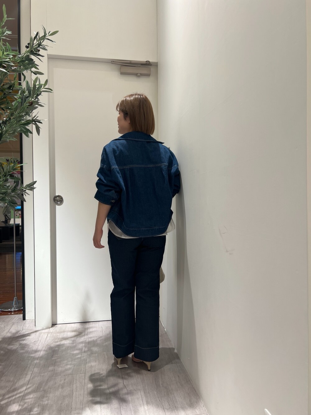 ブルー系のデニムジャケット、ホワイト系のシャツ/ブラウス、ブルー系のデニムパンツを着用したレディースの春コーディネートの3枚目の写真