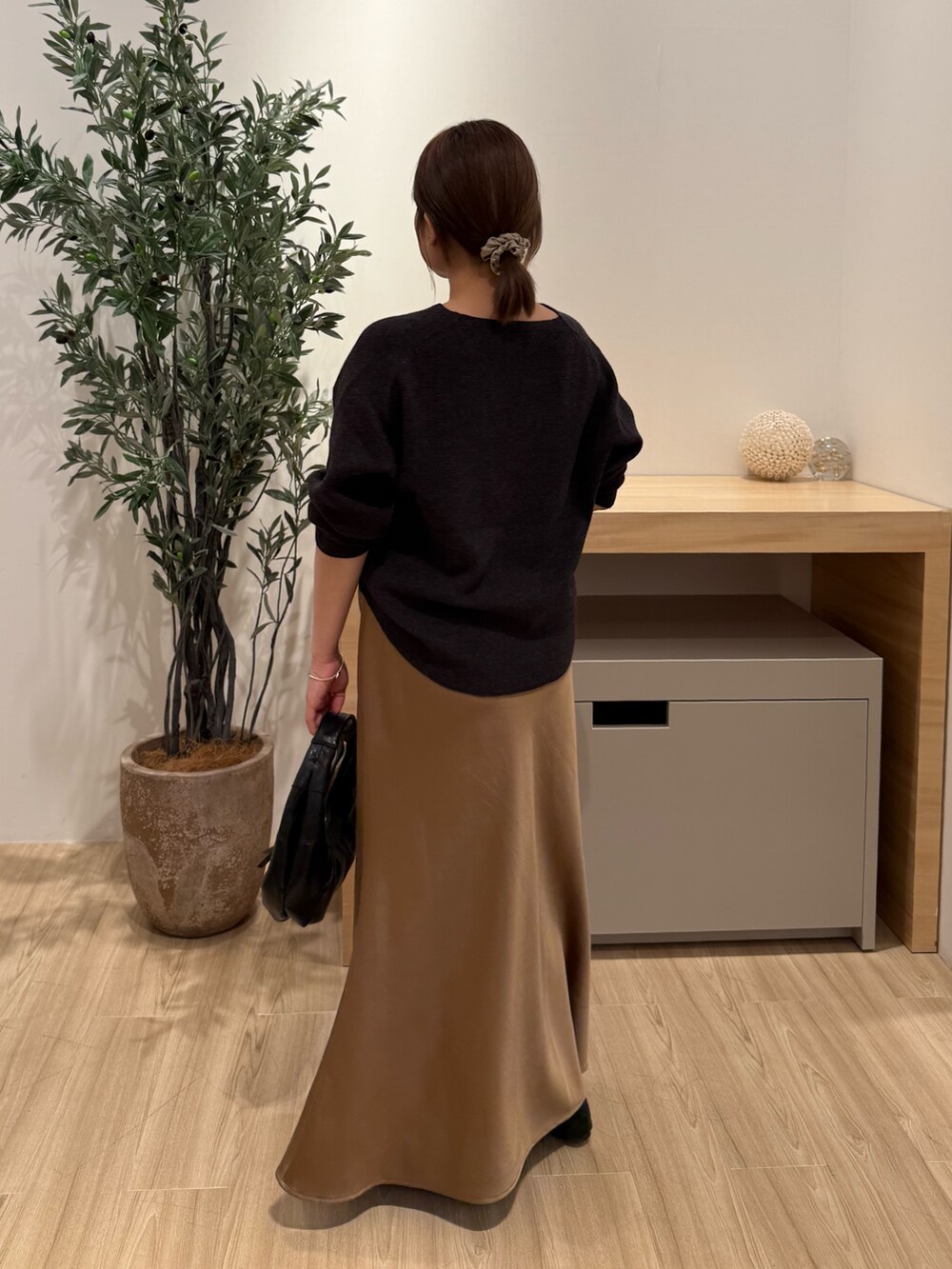 イエロー系のスカート、グレー系のニット/セーター、ブラック系のパンプスを着用したレディースの秋コーディネートの2枚目の写真