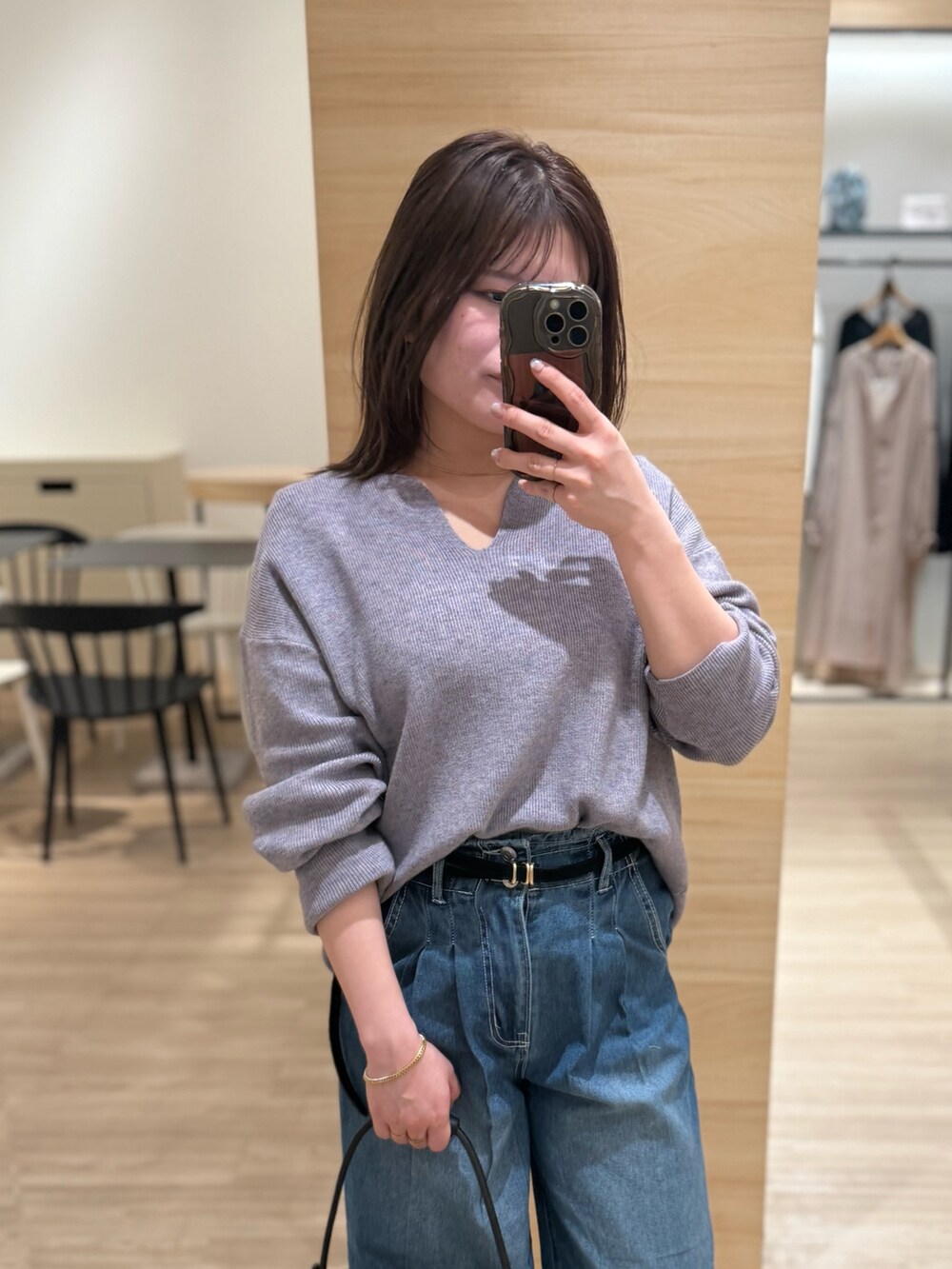 グレー系のニット/セーター、ブルー系のデニムパンツを着用したレディースの冬コーディネートの2枚目の写真