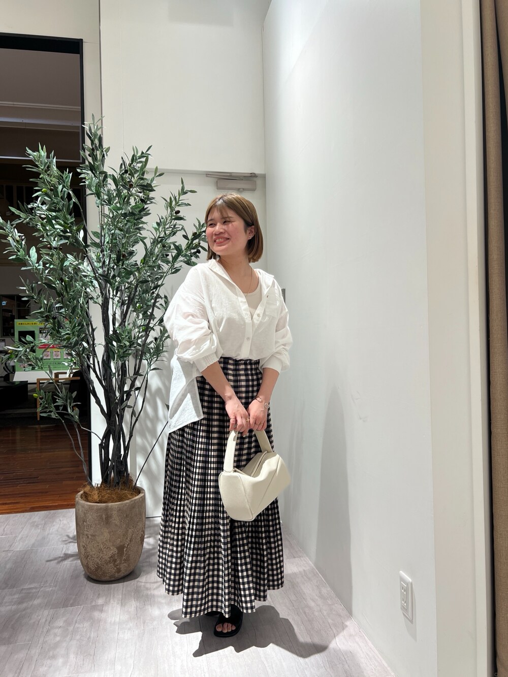 ホワイト系のシャツ/ブラウス、ベージュ系のキャミソール、ホワイト系のトートバッグを着用したレディースの春コーディネートの2枚目の写真