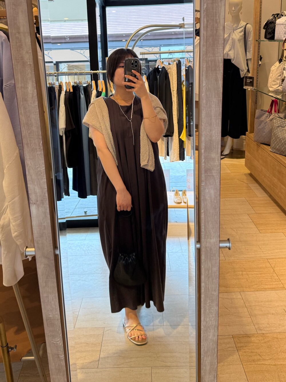 グレー系のワンピース、ベージュ系のニット/セーターを着用したレディースの春コーディネートの2枚目の写真