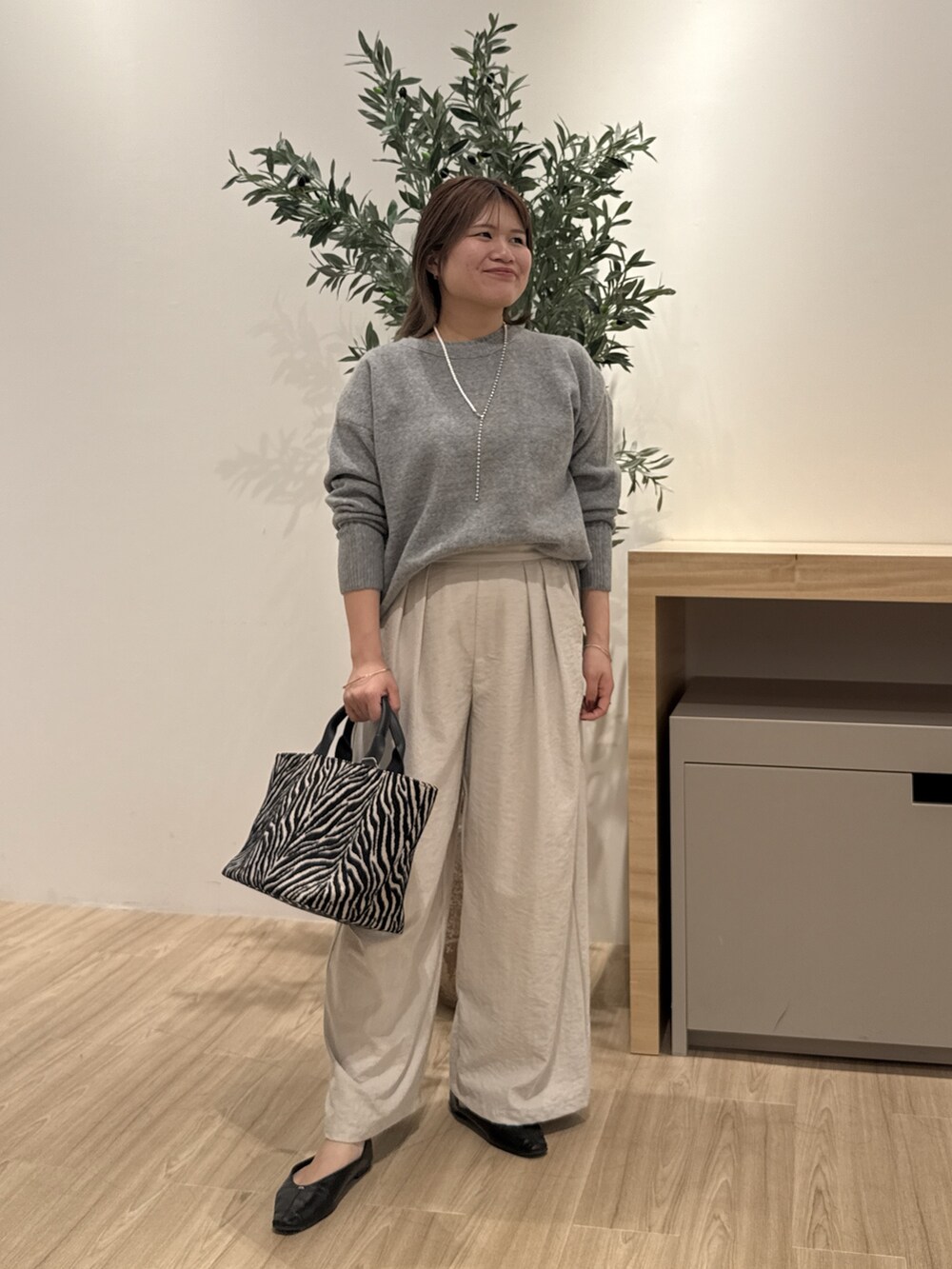 グレー系のその他パンツ、ブラック系のトートバッグ、ブラック系のパンプスを着用したレディースの秋コーディネートの3枚目の写真