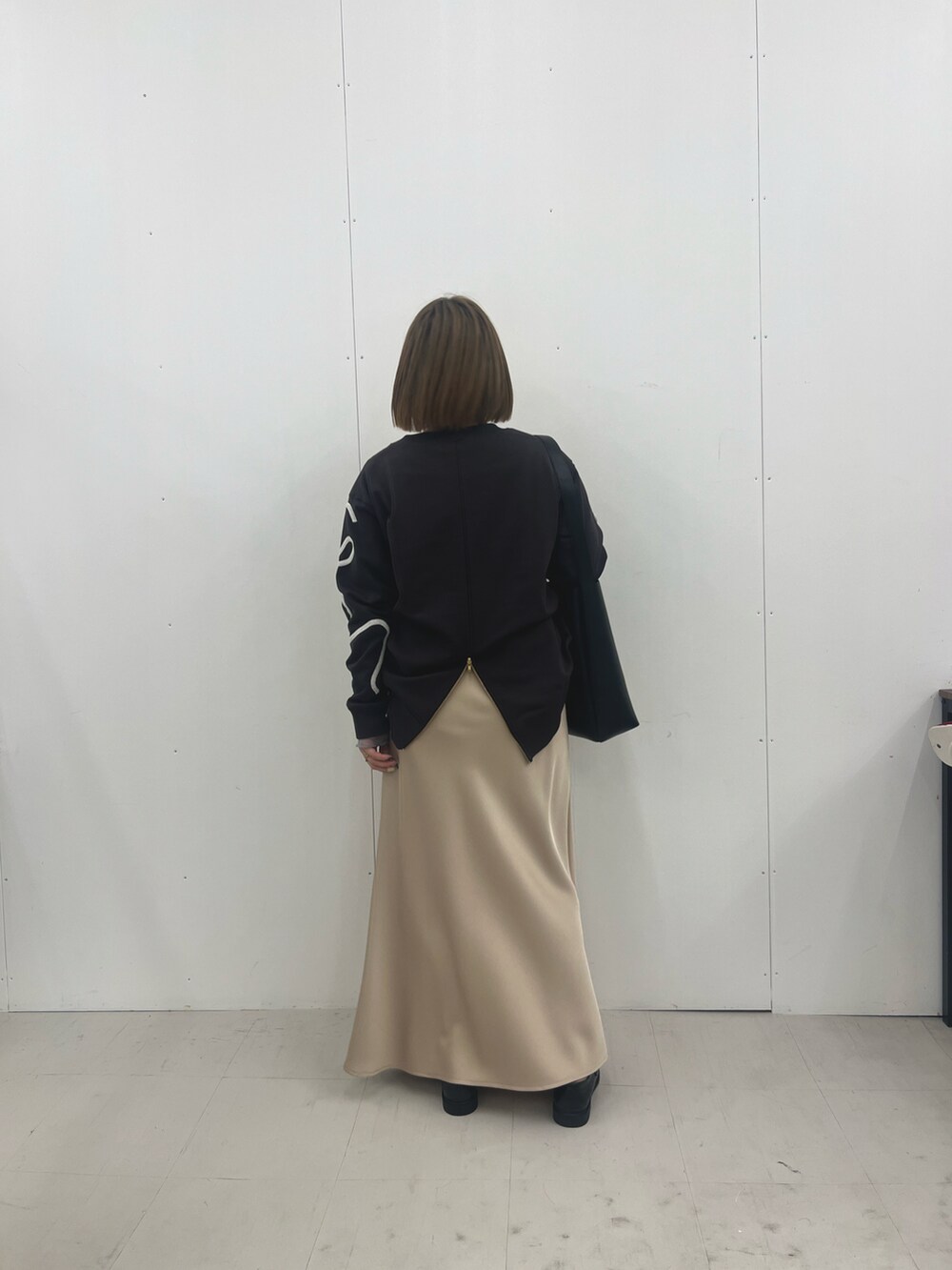 ベージュ系のスカート、グレー系のTシャツ/カットソーを着用したレディースの冬コーディネートの3枚目の写真