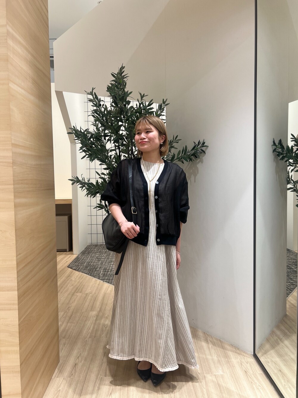 ブラック系のカーディガン/ボレロ、ベージュ系のワンピース、ゴールド系のリングを着用したレディースの春コーディネートの2枚目の写真