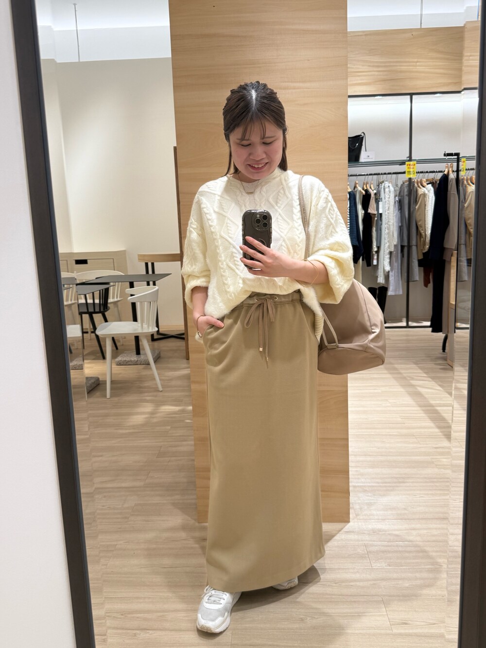 ホワイト系のニット/セーター、グリーン系のスカートを着用したレディースの秋コーディネートの4枚目の写真