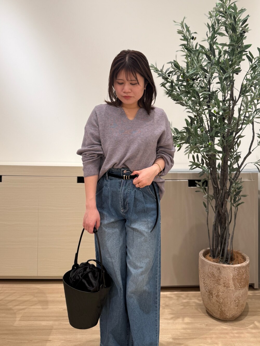 グレー系のニット/セーター、ブルー系のデニムパンツを着用したレディースの冬コーディネートの3枚目の写真