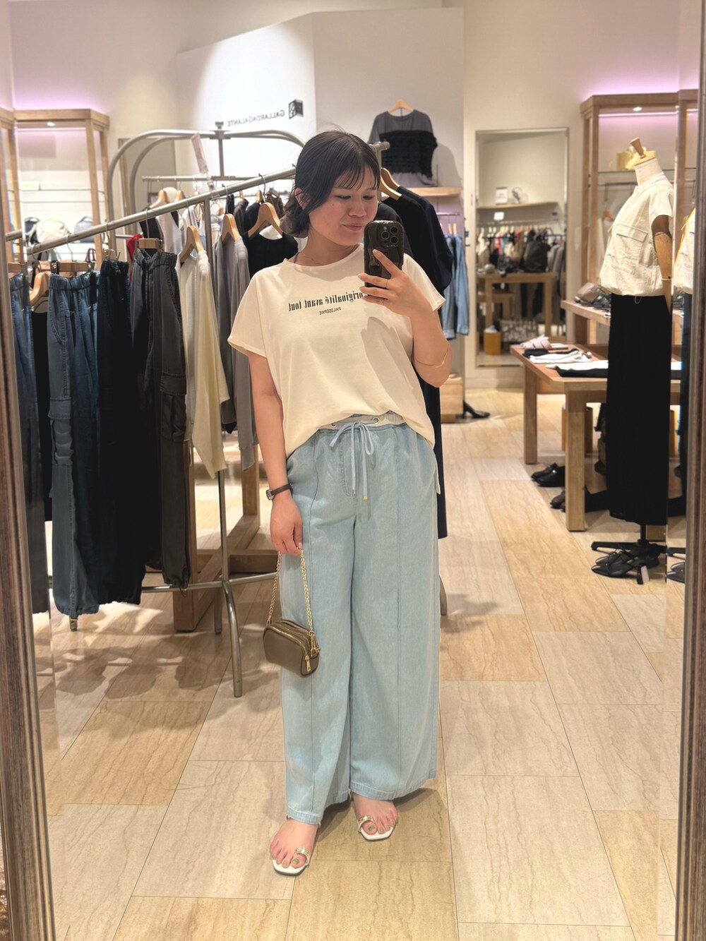 ホワイト系のTシャツ/カットソー、ブルー系のデニムパンツを着用したレディースの夏コーディネートの2枚目の写真