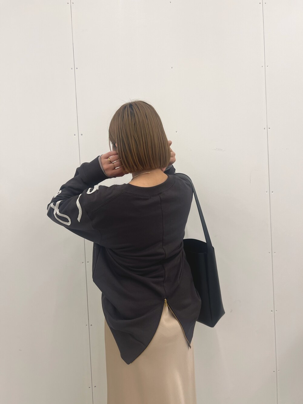 ベージュ系のスカート、グレー系のTシャツ/カットソーを着用したレディースの冬コーディネートの4枚目の写真