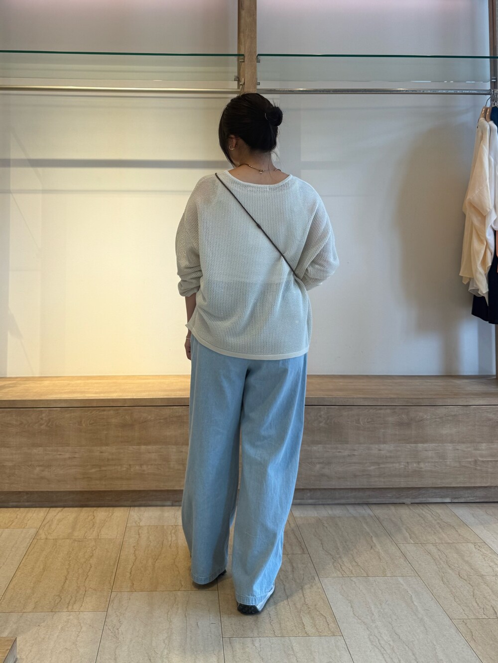 ホワイト系のニット/セーター、ブルー系のデニムパンツを着用したレディースの夏コーディネートの3枚目の写真
