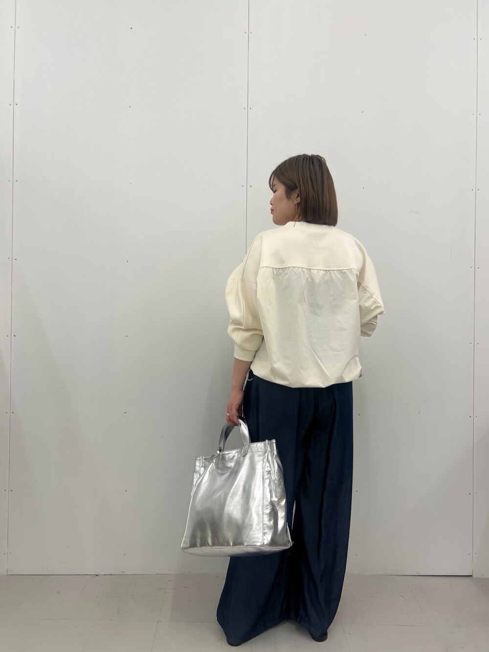 ホワイト系のTシャツ/カットソー、ブルー系のその他パンツ、シルバー系のトートバッグを着用したレディースの春コーディネートの2枚目の写真