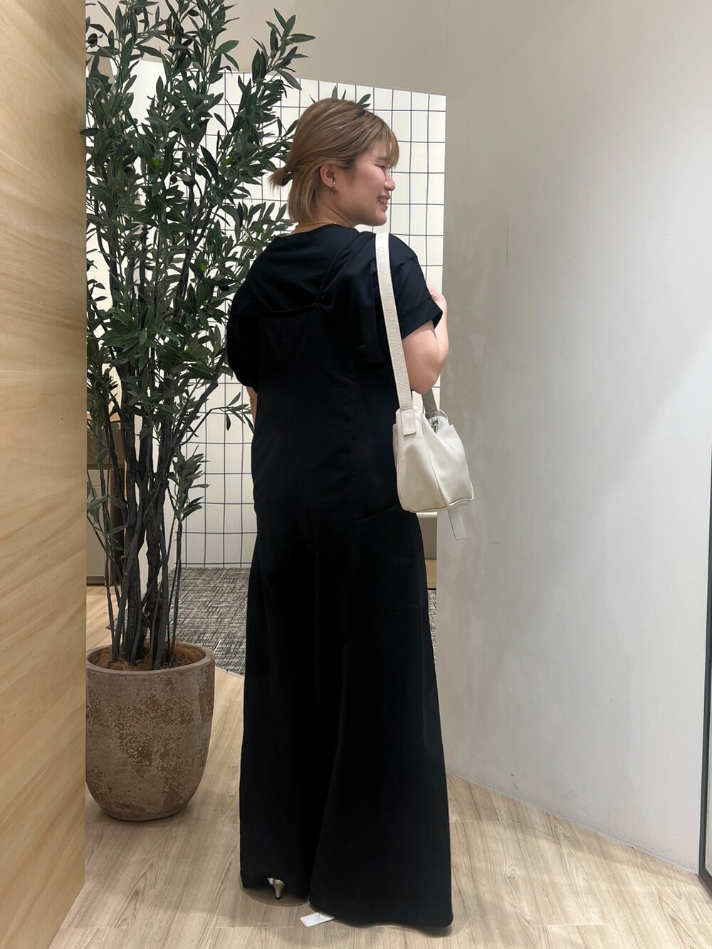 ブラック系のワンピース、ブラック系のTシャツ/カットソー、グレー系のショルダーバッグを着用したレディースの春コーディネートの2枚目の写真