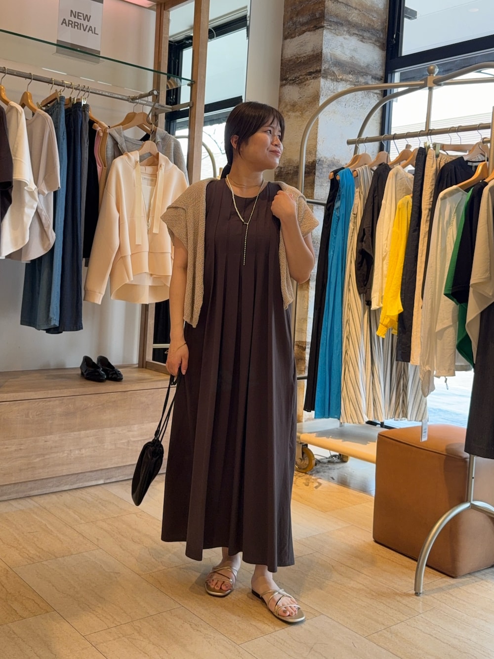 グレー系のワンピース、ベージュ系のニット/セーターを着用したレディースの春コーディネートの3枚目の写真