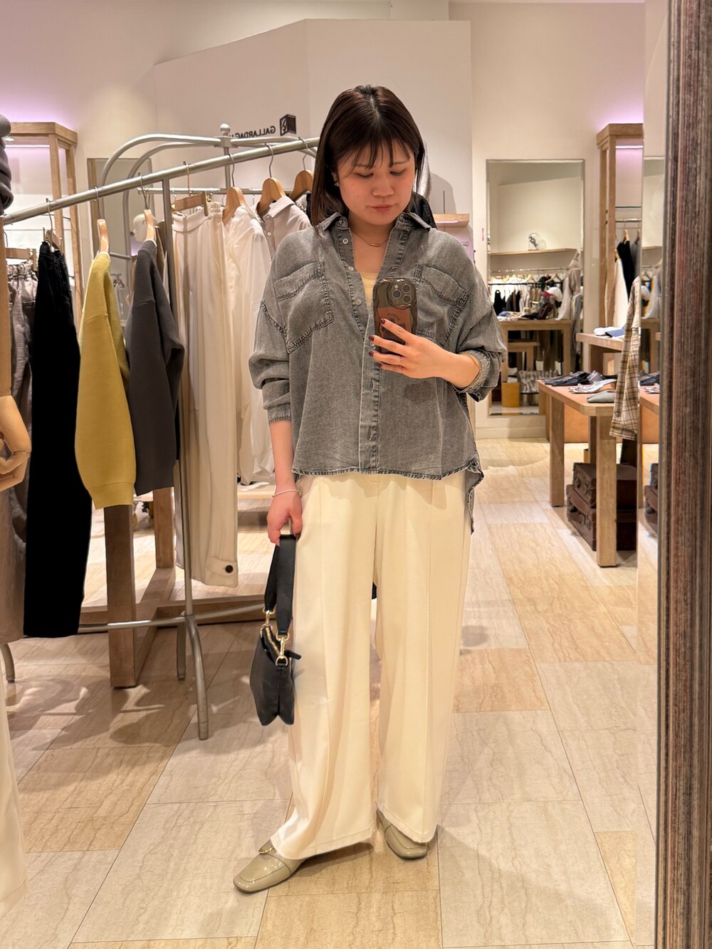 グレー系のシャツ/ブラウス、ホワイト系のその他パンツ、ブラック系のトートバッグを着用したレディースの春コーディネートの2枚目の写真