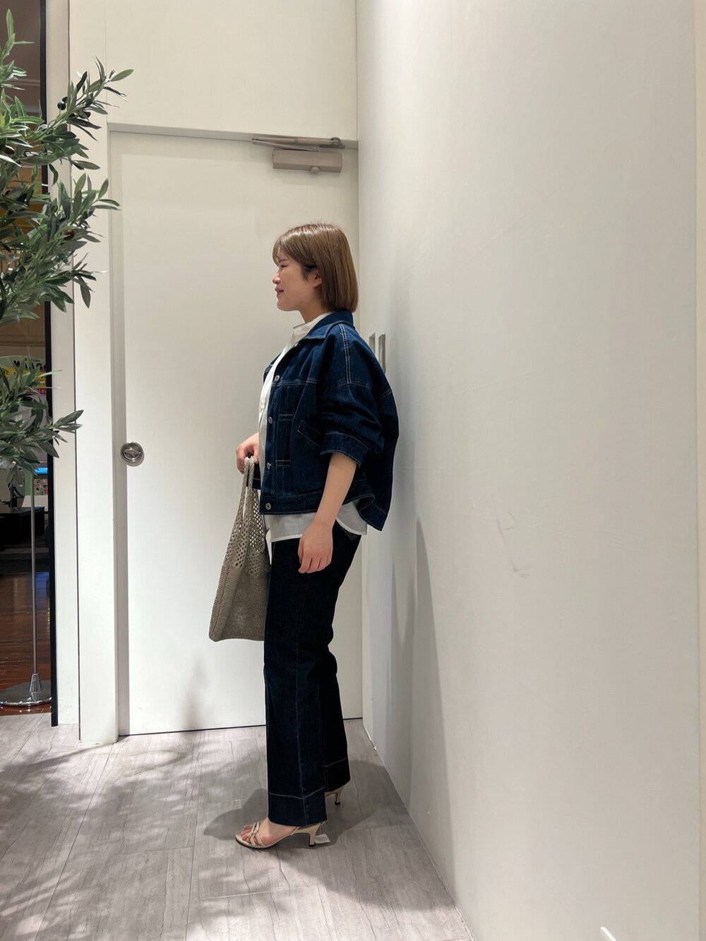 ブルー系のデニムジャケット、ホワイト系のシャツ/ブラウス、ブルー系のデニムパンツを着用したレディースの春コーディネートの2枚目の写真