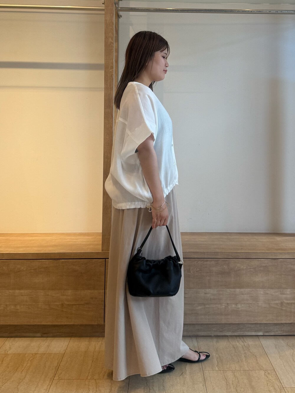 ベージュ系のスカート、ホワイト系のシャツ/ブラウス、グレー系のTシャツ/カットソーを着用したレディースの夏コーディネートの3枚目の写真