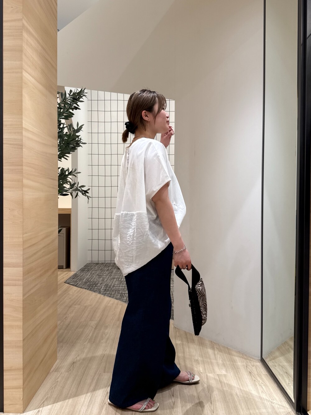 ブルー系のデニムパンツ、ホワイト系のTシャツ/カットソー、ホワイト系のサンダルを着用したレディースの夏コーディネートの4枚目の写真