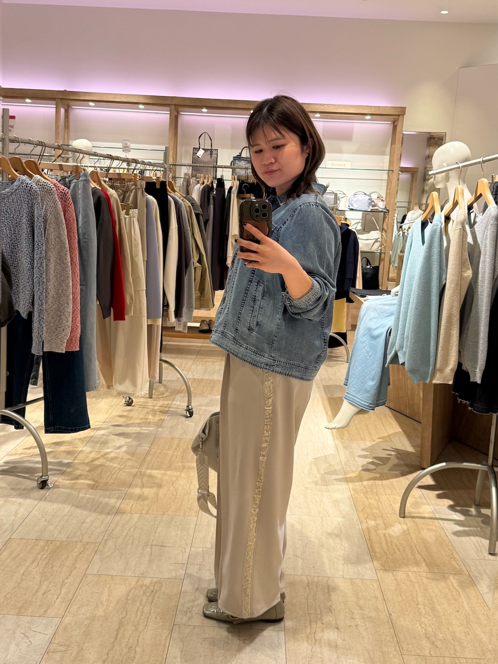 ホワイト系のその他パンツ、ブルー系のデニムジャケット、ホワイト系のトートバッグを着用したレディースの春コーディネートの3枚目の写真