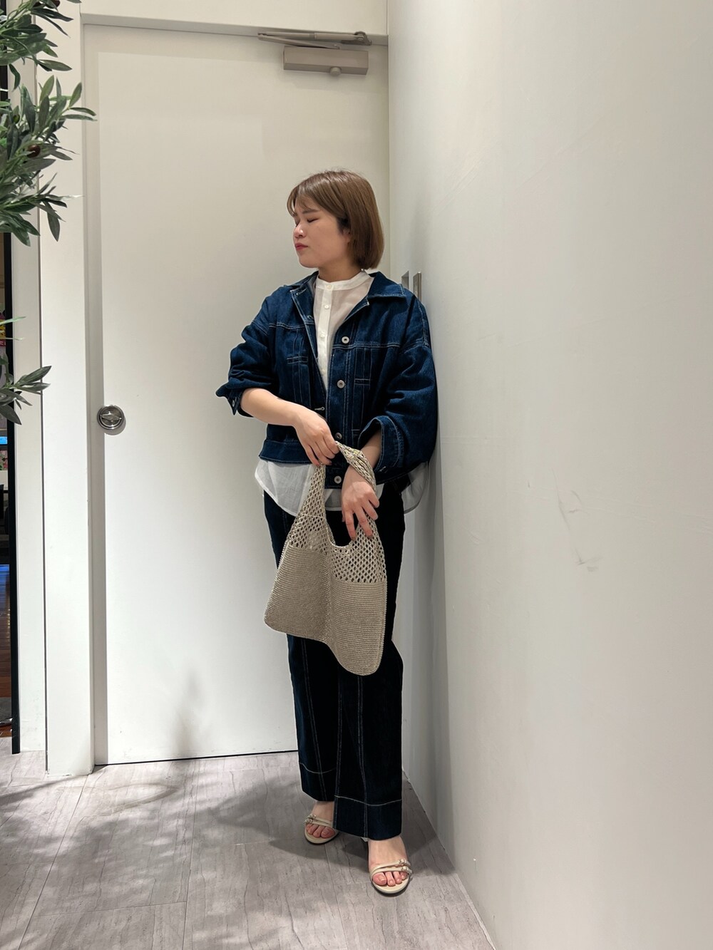 ブルー系のデニムジャケット、ホワイト系のシャツ/ブラウス、ブルー系のデニムパンツを着用したレディースの春コーディネートの4枚目の写真