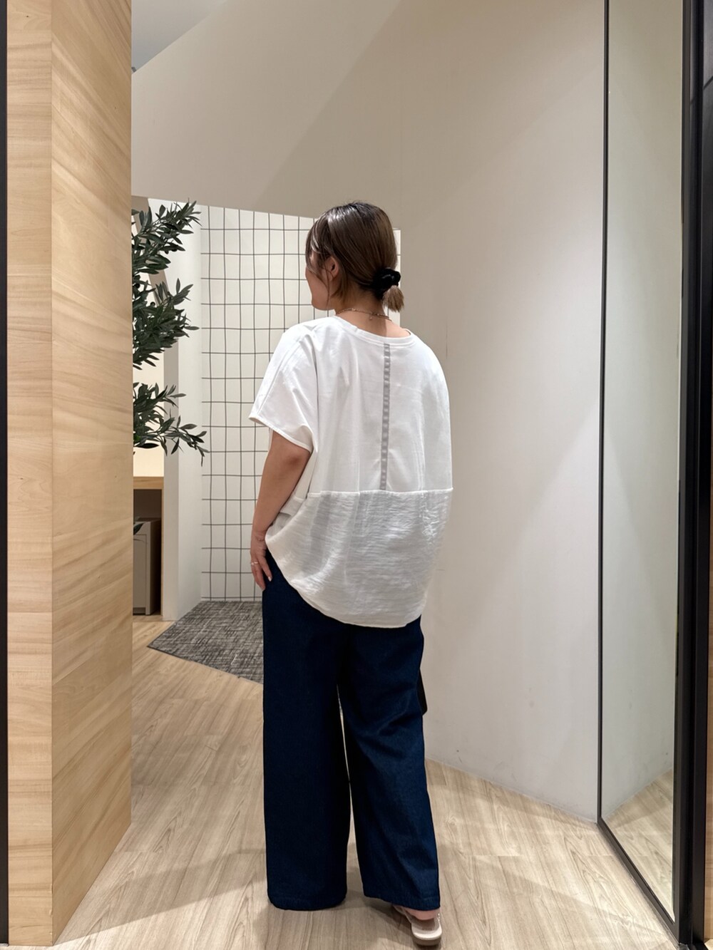 ブルー系のデニムパンツ、ホワイト系のTシャツ/カットソー、ホワイト系のサンダルを着用したレディースの夏コーディネートの3枚目の写真