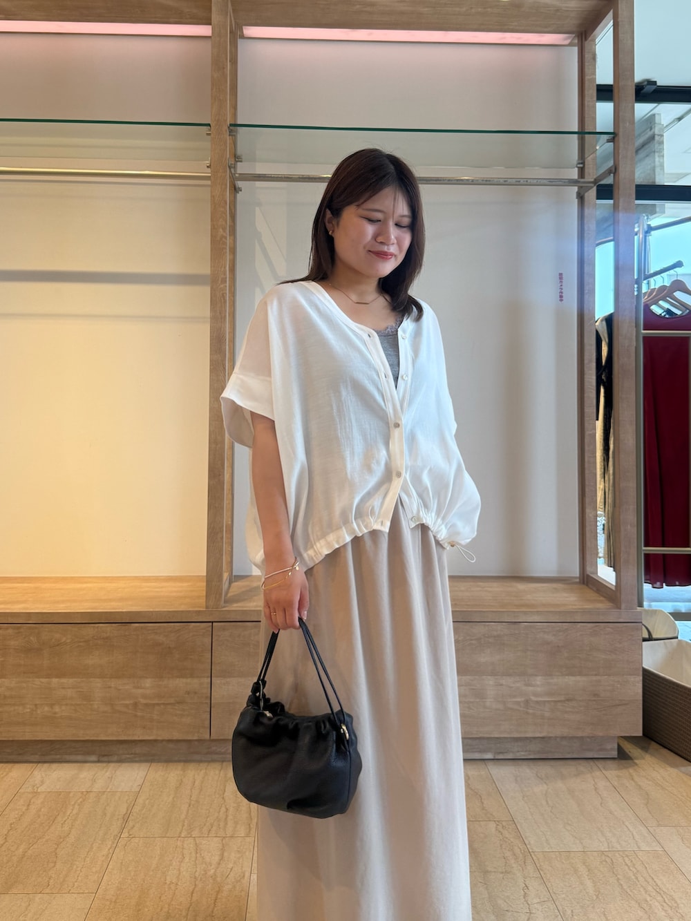 ベージュ系のスカート、ホワイト系のシャツ/ブラウス、グレー系のTシャツ/カットソーを着用したレディースの夏コーディネートの2枚目の写真