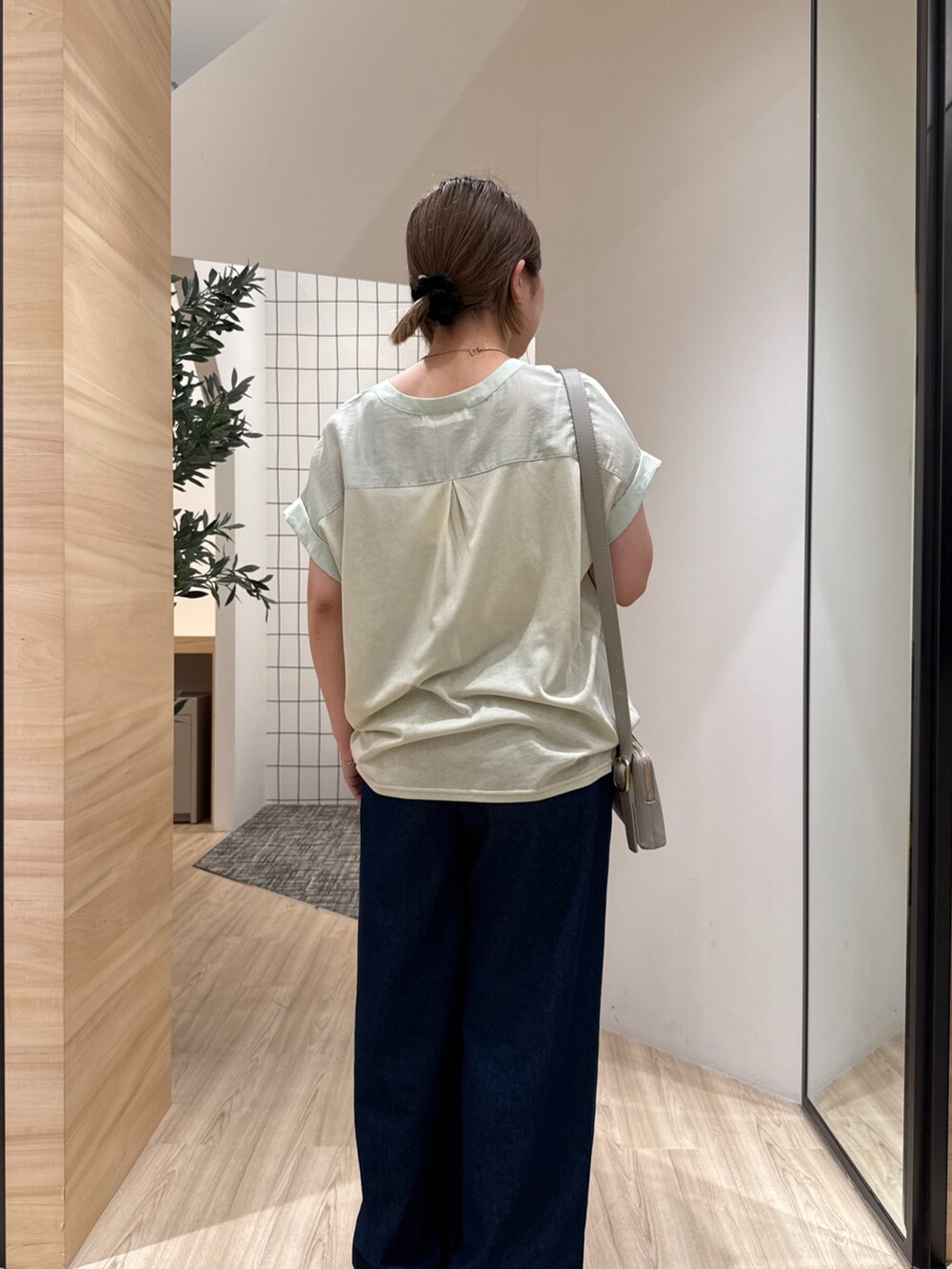 ブルー系のデニムパンツ、グリーン系のシャツ/ブラウス、グレー系のショルダーバッグを着用したレディースの夏コーディネートの5枚目の写真