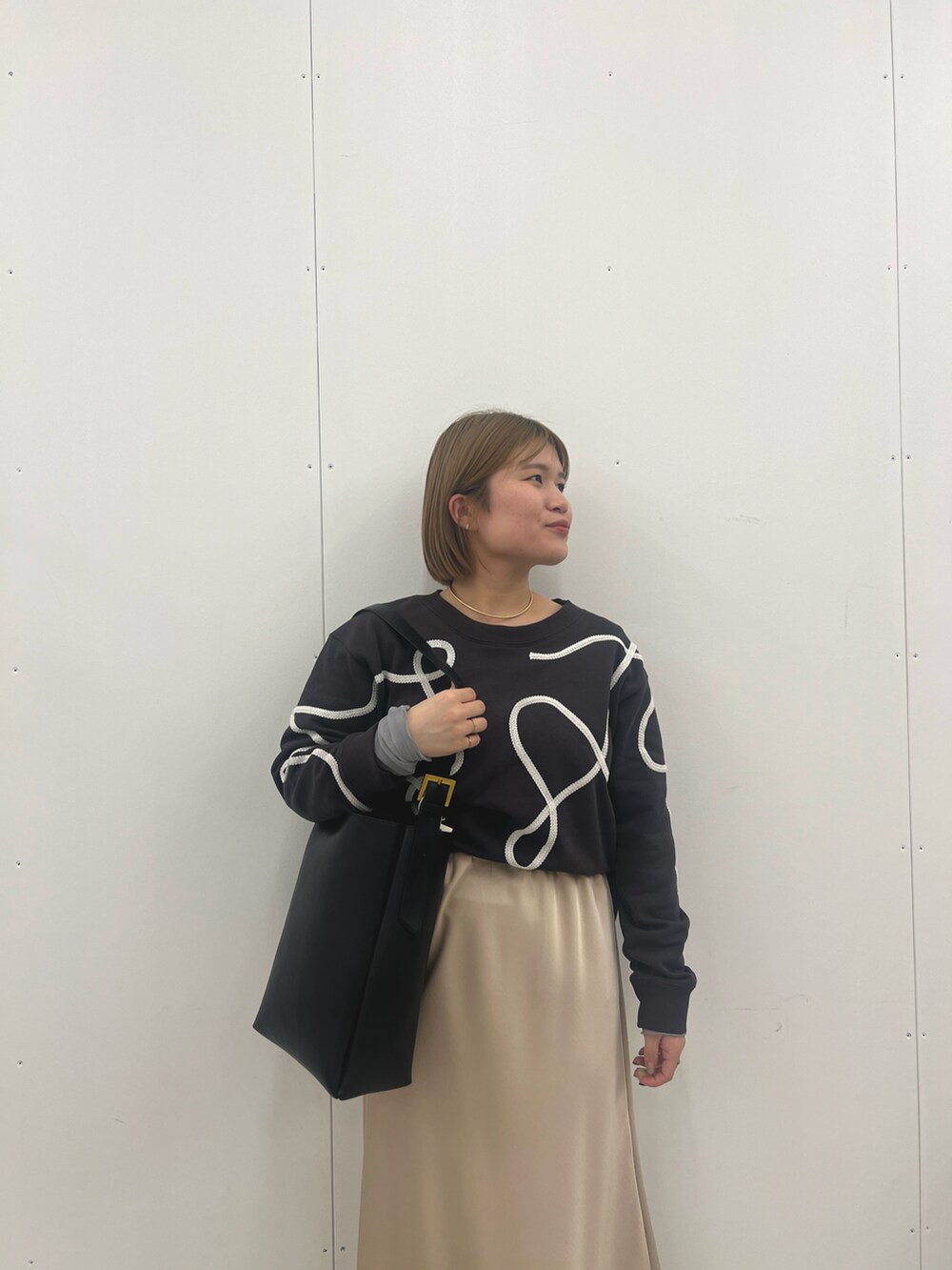 ベージュ系のスカート、グレー系のTシャツ/カットソーを着用したレディースの冬コーディネートの5枚目の写真