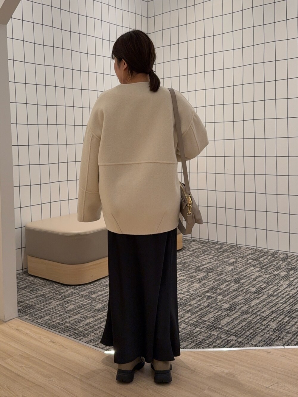 ベージュ系のノーカラージャケット、ブラック系のスカートを着用したレディースの秋コーディネートの3枚目の写真