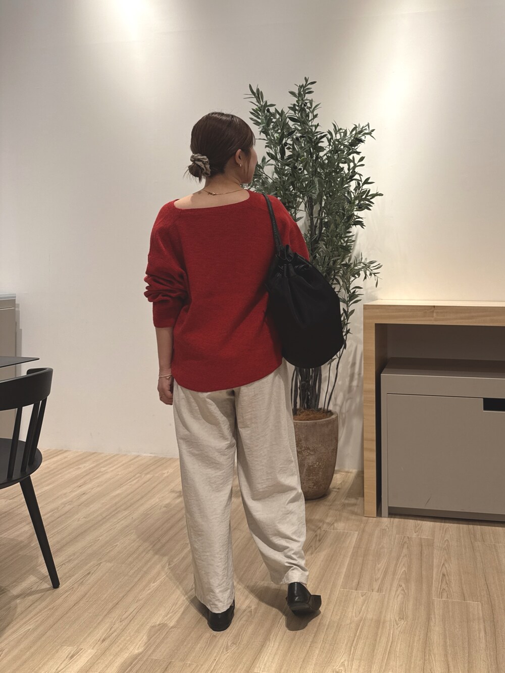 グレー系のその他パンツ、レッド系のニット/セーター、ブラック系のパンプスを着用したレディースの秋コーディネートの3枚目の写真