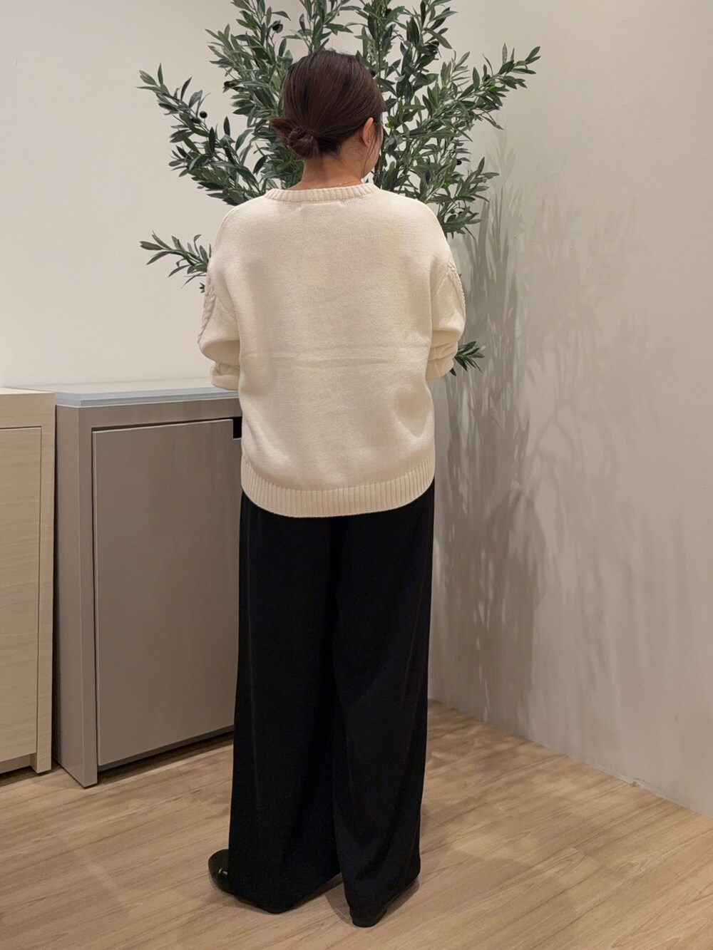 ホワイト系のニット/セーター、ブラック系のその他パンツを着用したレディースの冬コーディネートの2枚目の写真