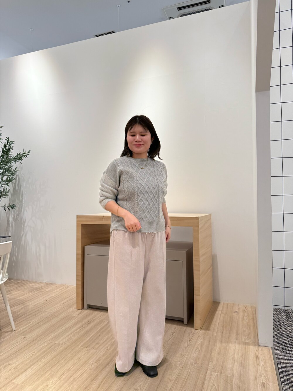 グレー系のニット/セーター、ベージュ系のその他パンツを着用したレディースの秋コーディネートの3枚目の写真