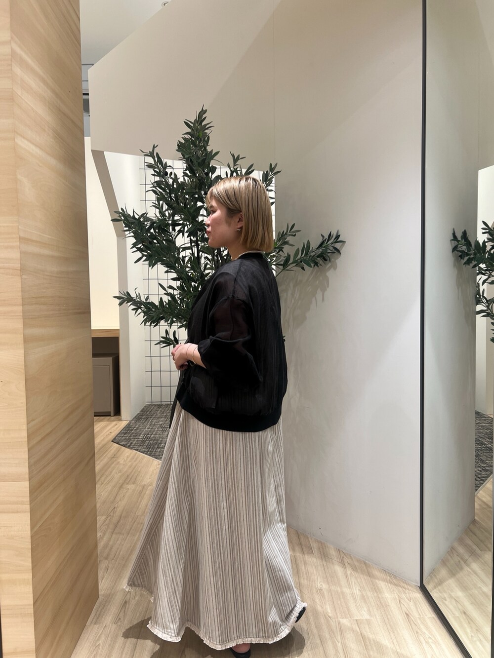 ブラック系のカーディガン/ボレロ、ベージュ系のワンピース、ゴールド系のリングを着用したレディースの春コーディネートの3枚目の写真