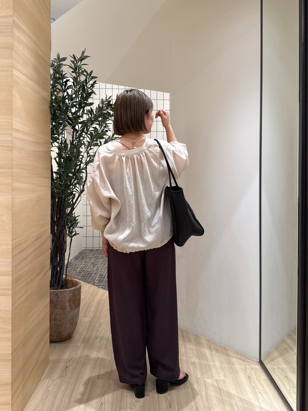 ベージュ系のシャツ/ブラウス、グレー系のその他パンツ、ブラック系のトートバッグを着用したレディースの夏コーディネートの2枚目の写真