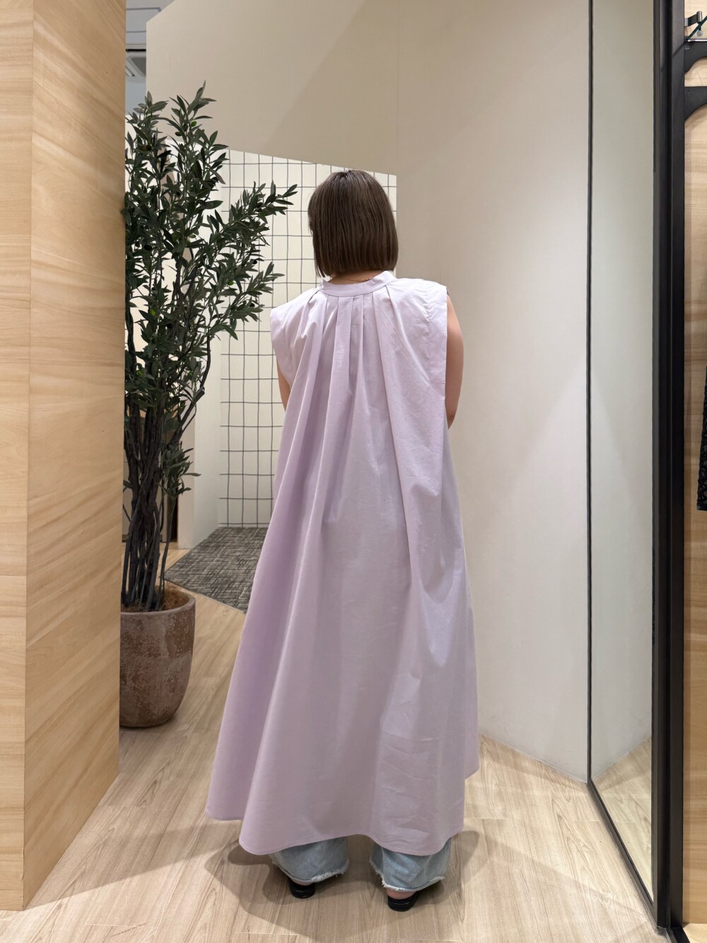 パープル系のワンピース、ブラック系のトートバッグ、ブルー系のその他パンツを着用したレディースの春コーディネートの3枚目の写真