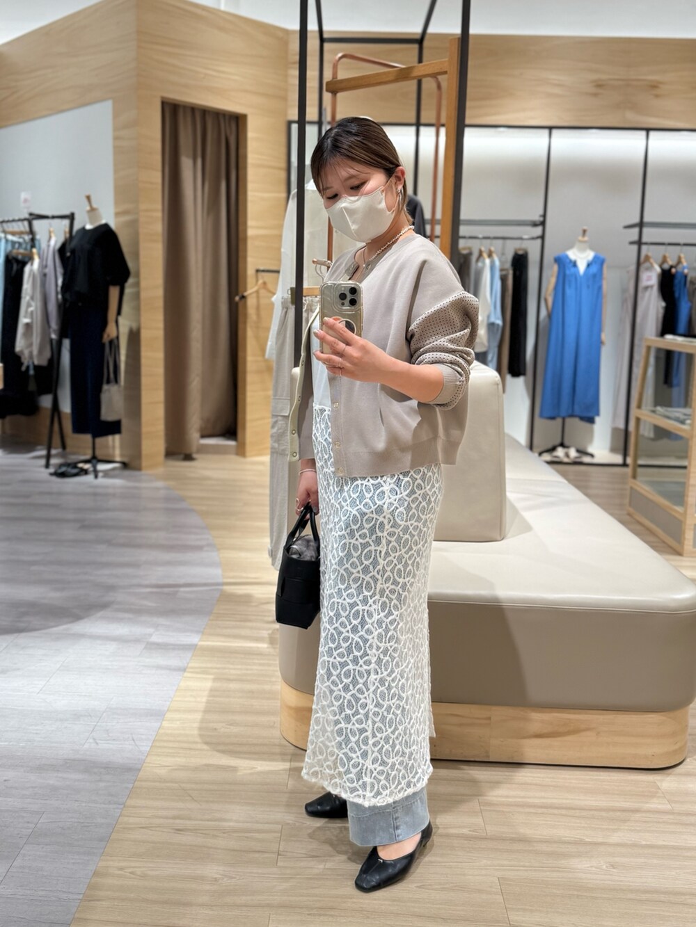 ホワイト系のワンピース、グレー系のカーディガン/ボレロ、ブラック系のトートバッグを着用したレディースの夏コーディネートの3枚目の写真