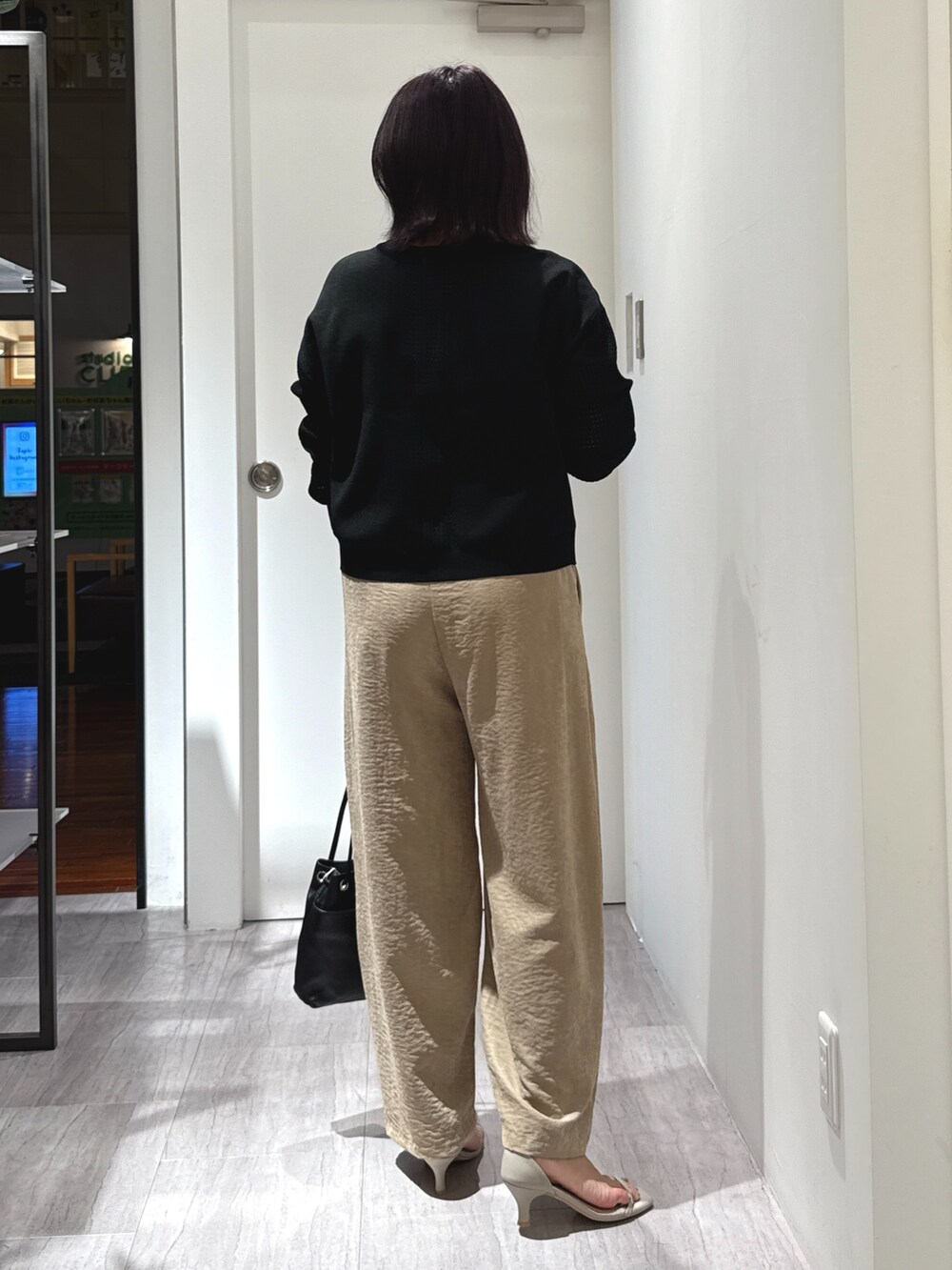 ブラック系のカーディガン/ボレロ、ベージュ系のその他パンツ、ブラック系のトートバッグを着用したレディースの夏コーディネートの3枚目の写真