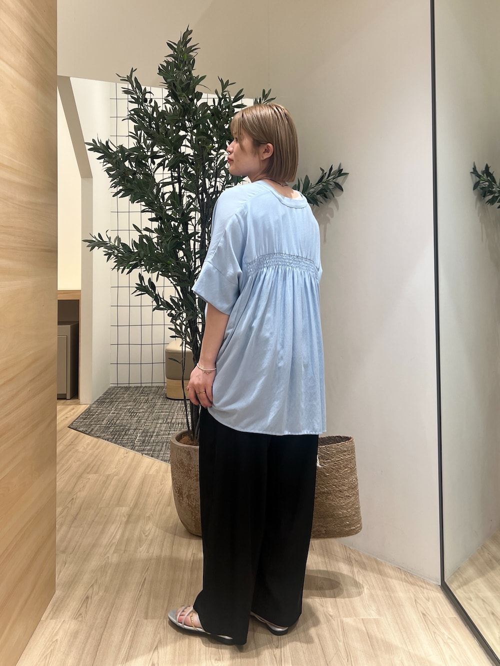 ブルー系のシャツ/ブラウス、ブラック系のその他パンツ、ホワイト系のトートバッグを着用したレディースの春コーディネートの2枚目の写真