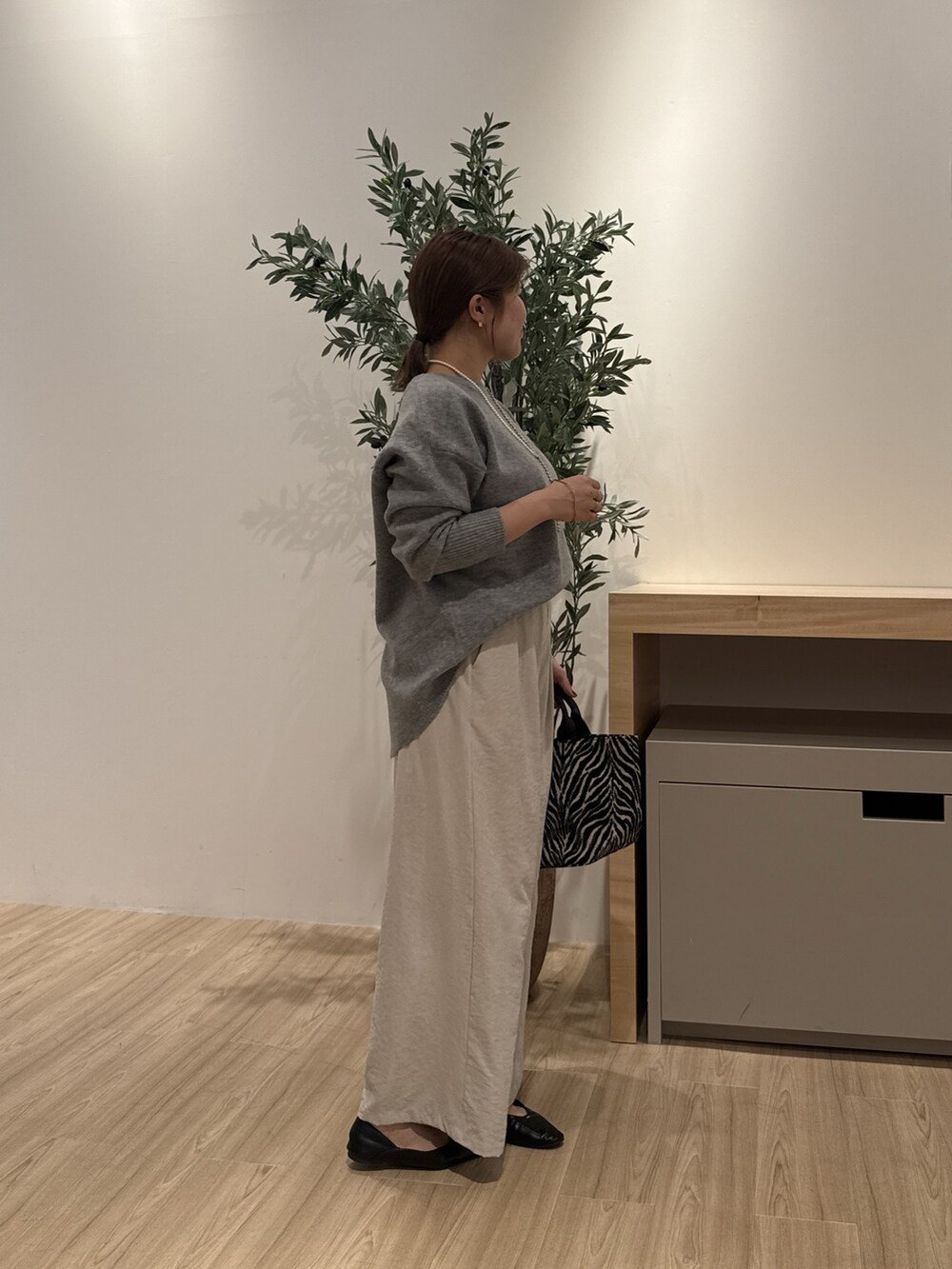 グレー系のその他パンツ、ブラック系のトートバッグ、ブラック系のパンプスを着用したレディースの秋コーディネートの2枚目の写真