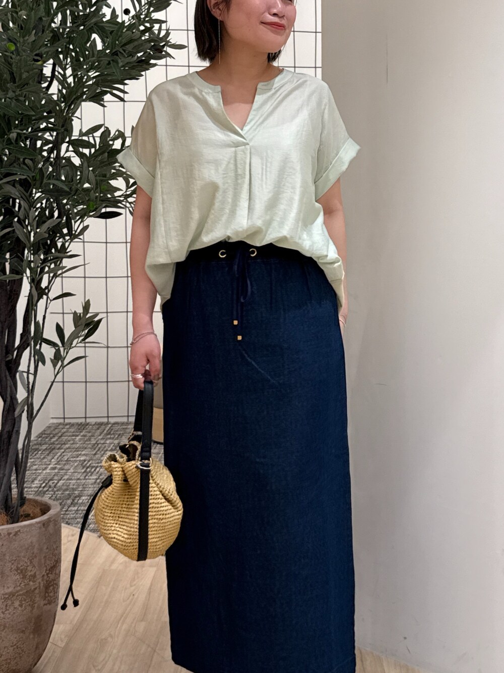 ブルー系のスカート、グリーン系のシャツ/ブラウス、ベージュ系のトートバッグを着用したレディースの夏コーディネートの4枚目の写真